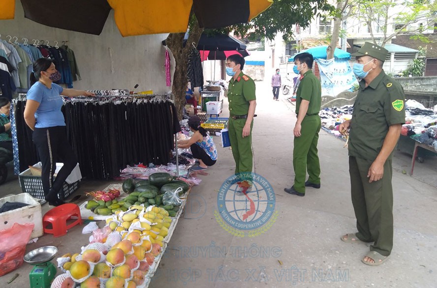 Lực lượng chức năng nhắc nhở người dân chấp hành công tác phòng, chống dịch Covid-19 tại chợ Vồi (huyện Thường Tín).
