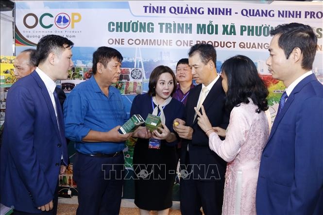 Bộ trưởng Bộ Công Thương Lào Malaythong Kommasith và các đại biểu tham quan các sản phẩm của Việt Nam tại Hội chợ. Ảnh: Phạm Kiên/Pv TTXVN tại Lào